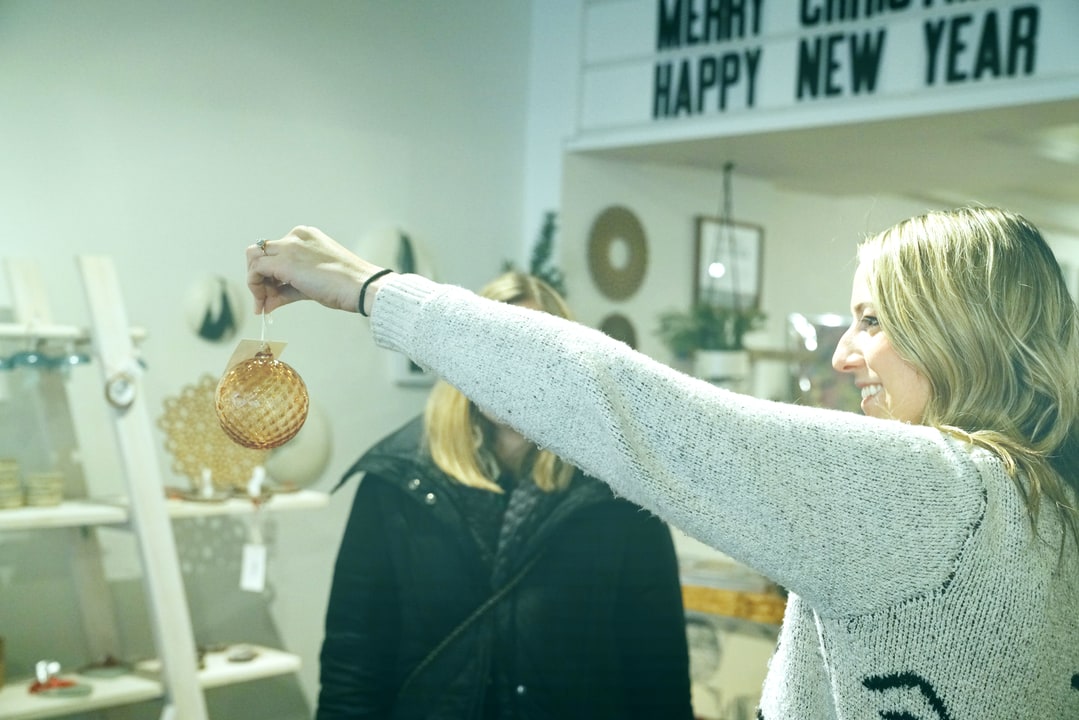 Samantha Fisher holding an ornament for a customer at PG&H retail shop downtown